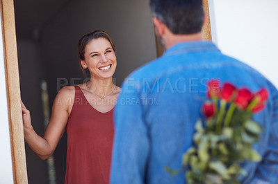 Buy stock photo Cropped shot of an unrecognizable man facing his girlfriend while hiding a bunch of roses behind his back