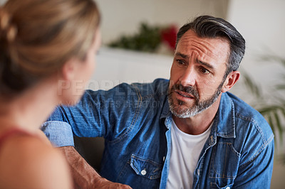 Buy stock photo Cropped shot of a mature man looking worried while having a discussion with his wife at home