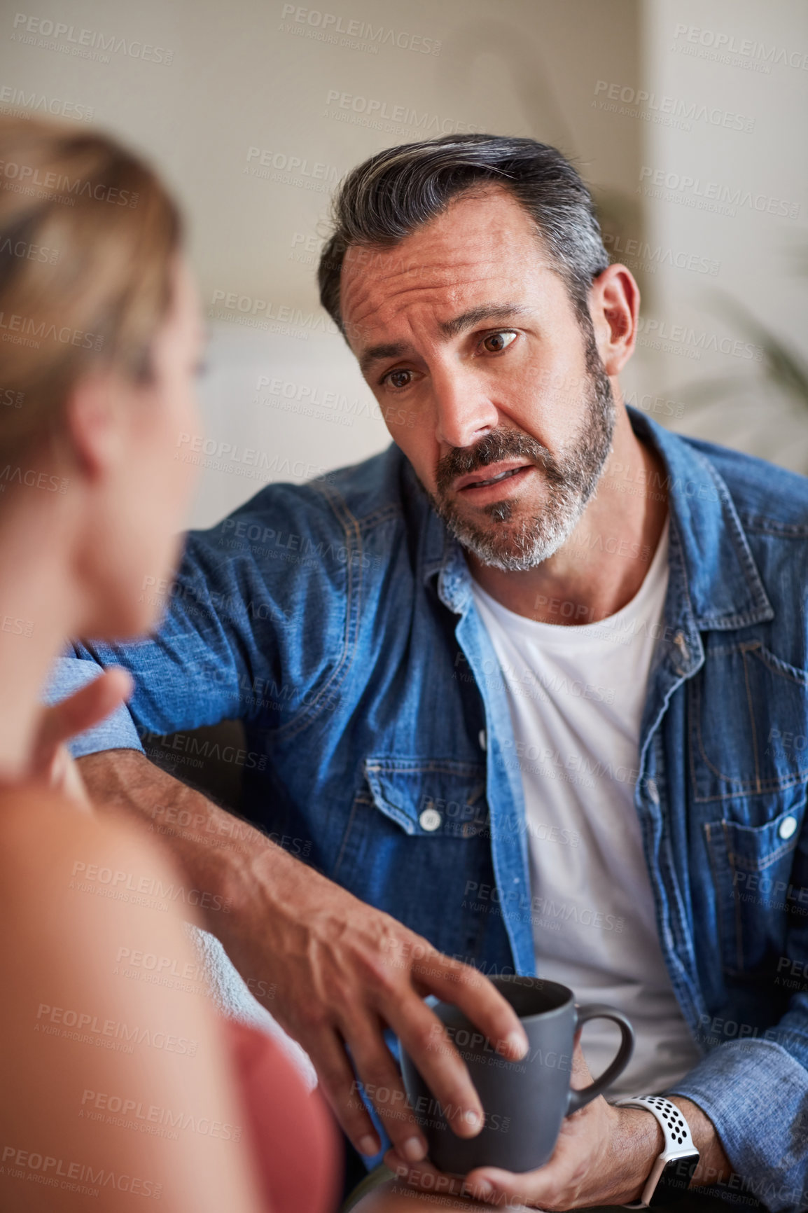 Buy stock photo Cropped shot of a mature man looking worried while having a discussion with his wife at home