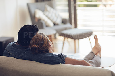 Buy stock photo High angle shot of an unrecognizable couple relaxing on their couch at home