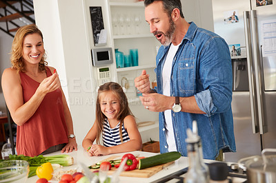 Buy stock photo Shot of an adorable little girl cooking with her mother and father at home