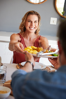 Buy stock photo Shot of a happy young woman having a meal with her husband at home