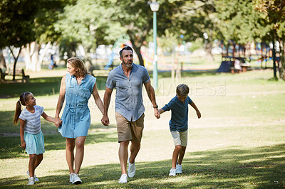 Buy stock photo Shot of a happy young family going for a walk in the park
