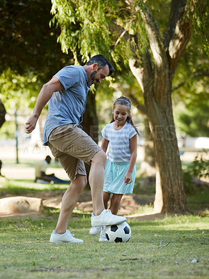 Buy stock photo Shot of an adorable little girl playing soccer with her father in the park