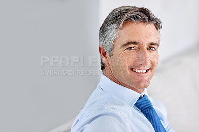 Buy stock photo Headshot of a confident mature businessman wearing a suit and smiling while sitting indoors