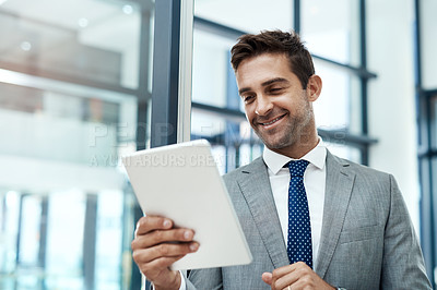 Buy stock photo Shot of a professional businessman using a digital tablet in his office