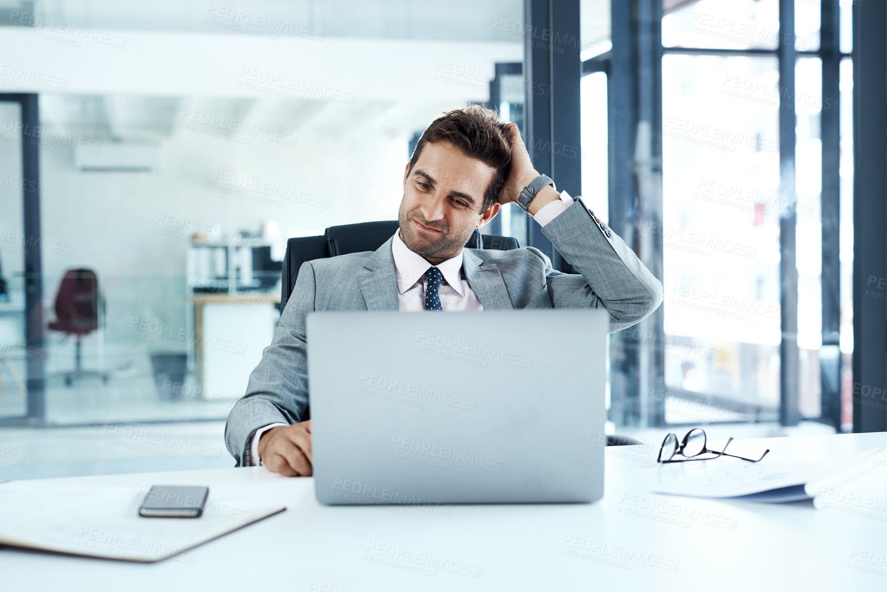 Buy stock photo Cropped shot of a businessman looking confused while sitting at his desk