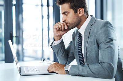 Buy stock photo Shot of a professional businessman sitting at his desk