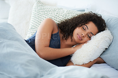 Buy stock photo Shot of an attractive young woman sleeping under a duvet in bed during the morning