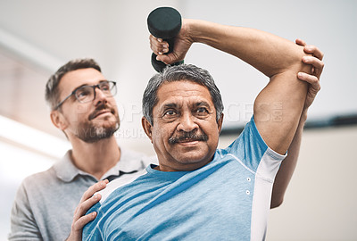 Buy stock photo Shot of a senior man exercising with dumbbells during a rehabilitation session with his physiotherapist