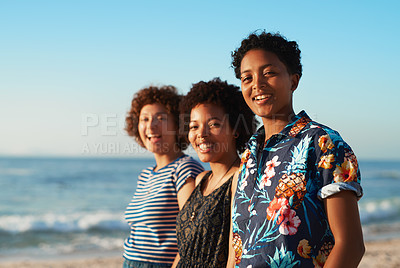 Buy stock photo Portrait of three attractive young women standing together and posing on the beach during the day