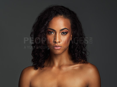 Buy stock photo Portrait of an attractive young woman posing shirtless and against a dark background in the studio