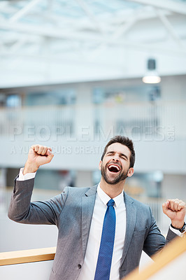 Buy stock photo Shot of a young businessman cheering in an office