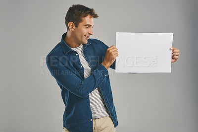 Buy stock photo Man, blank and placard with smile in studio for billboard announcement, presentation and branding logo. Male person, paper and advertising for news poster, signage and notification on gray background