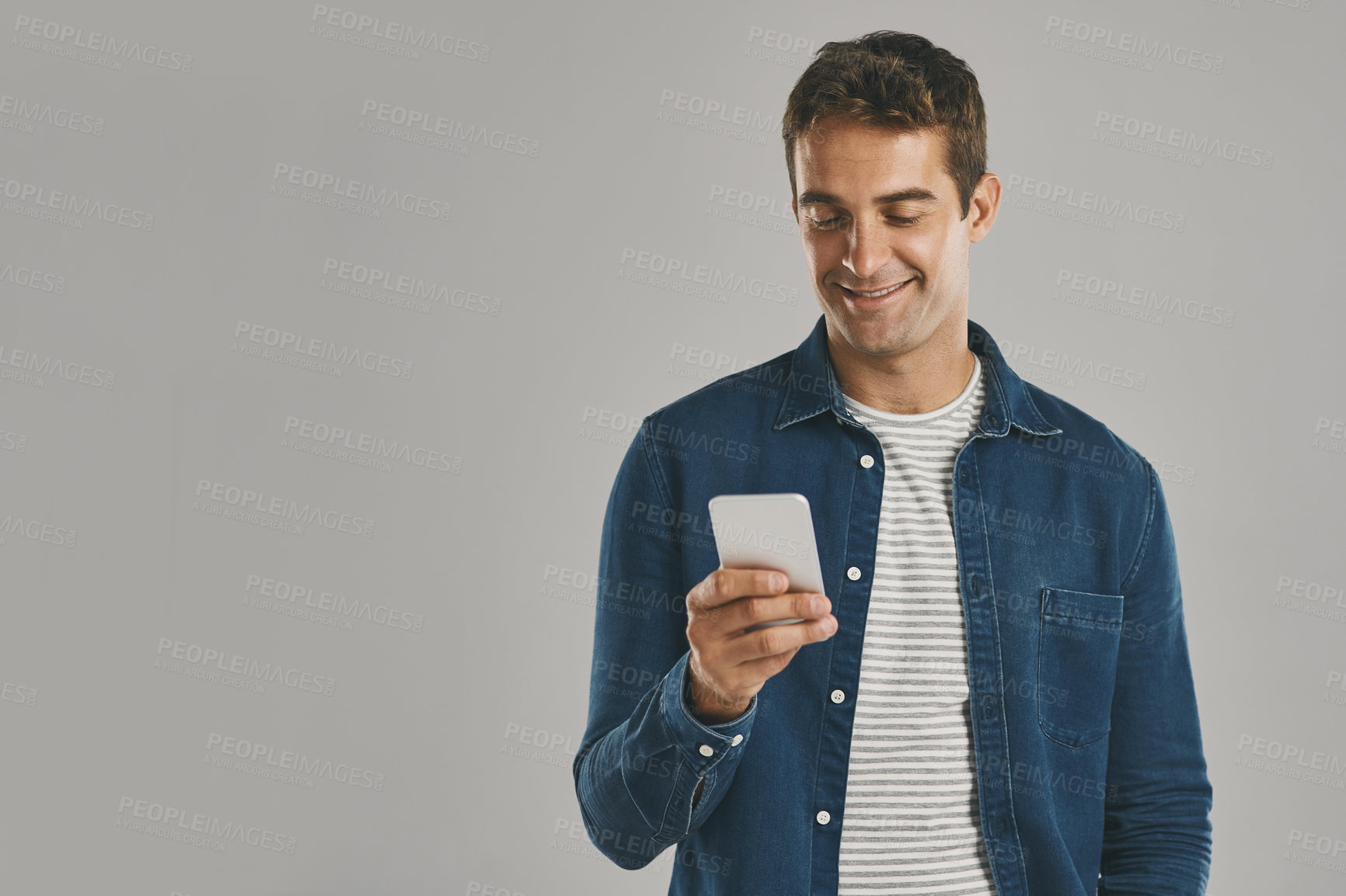 Buy stock photo Studio, man and smartphone with laugh, funny news and comedy with contact by mockup. Creative worker, networking and typing on mobile app with humor, chatting and connection by white background