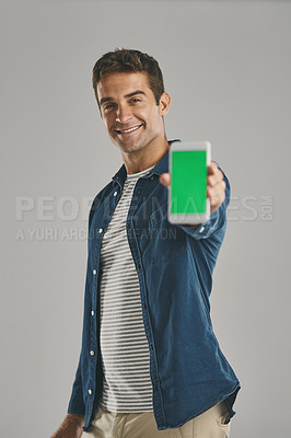 Buy stock photo Man, portrait and phone with green screen in studio for advertising, social media and branding website. Smile, person and mobile for tracking marker, contact announcement and offer on gray background