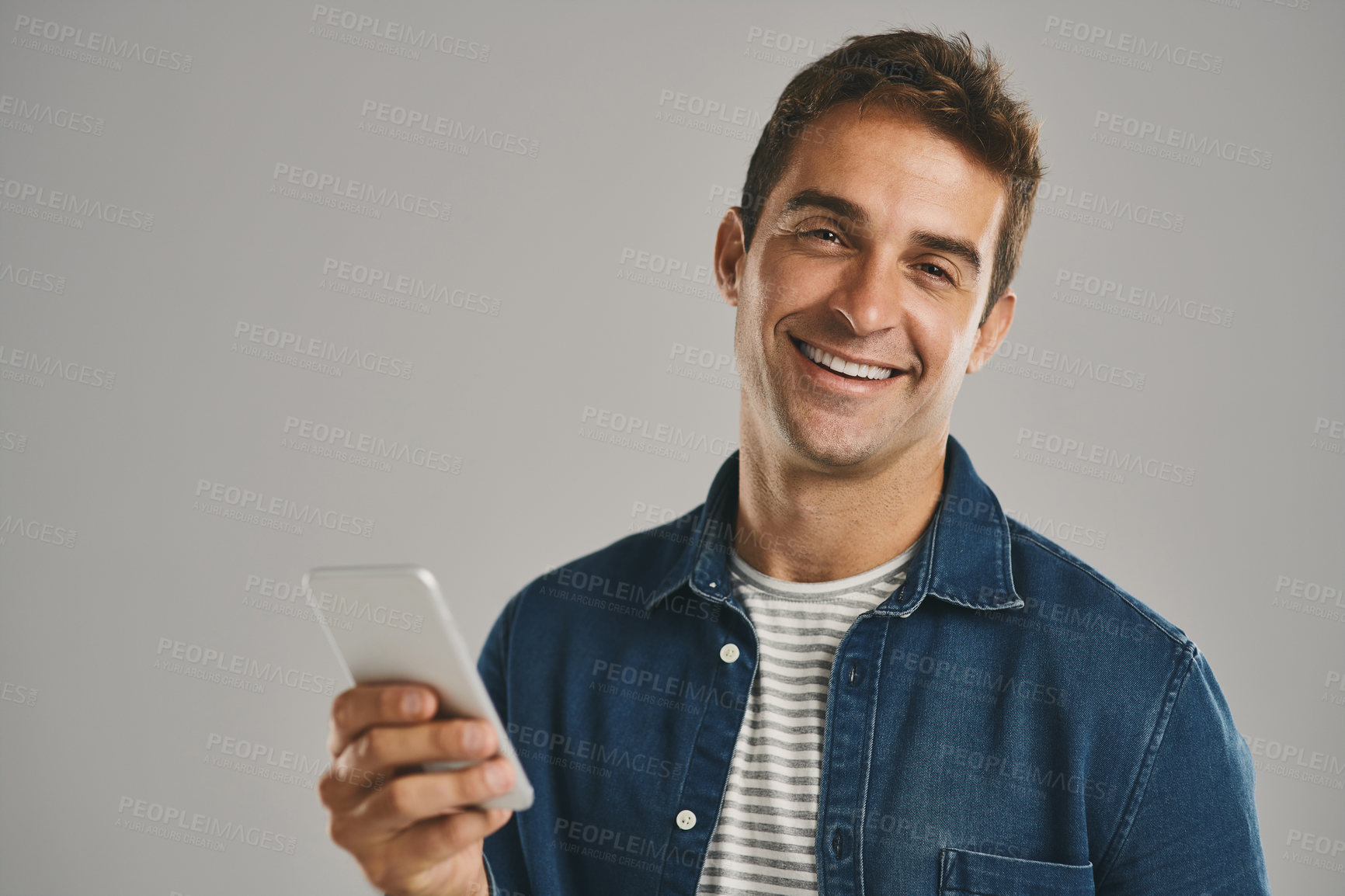 Buy stock photo Portrait, smile and man with smartphone, typing and internet with person on gray studio background. Face, guy and happy model with cellphone, social media or message to contact, texting or connection