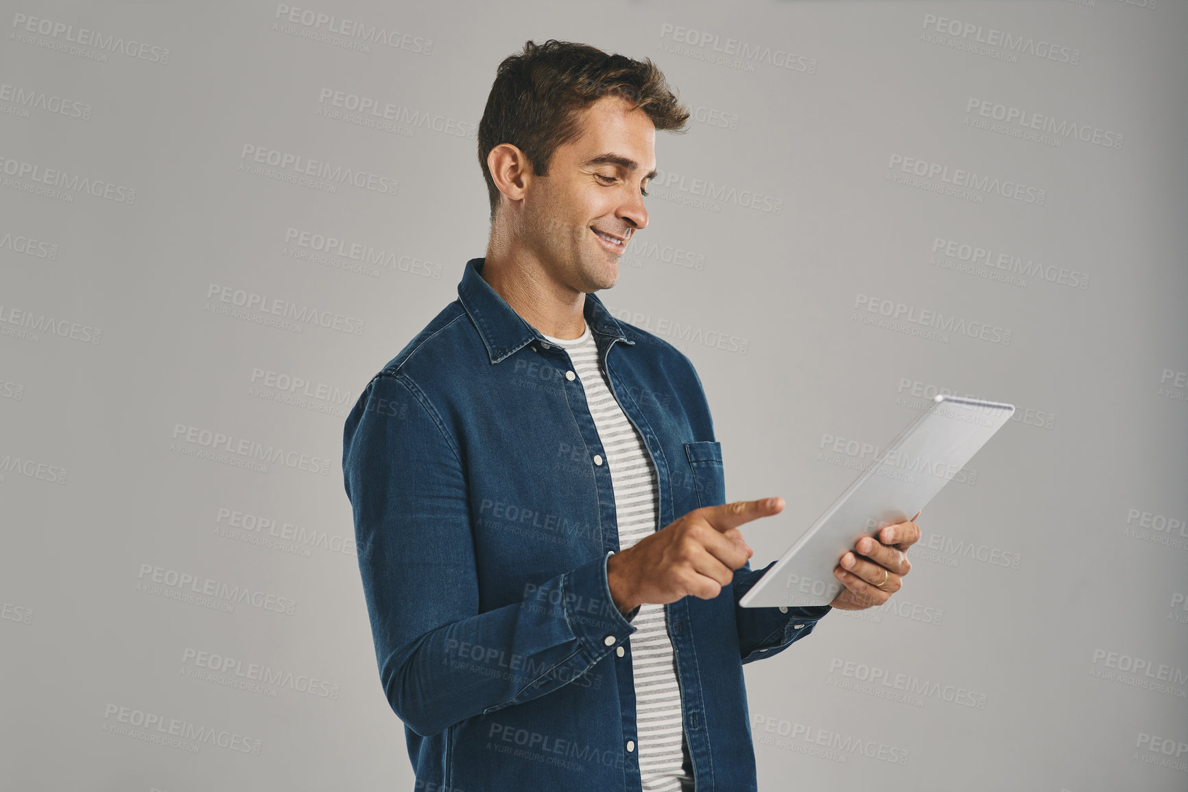 Buy stock photo Search, smile and tablet with man in studio isolated on gray background for app download or update. Ecommerce, social media and website with happy user in casual outfit for online shopping or retail