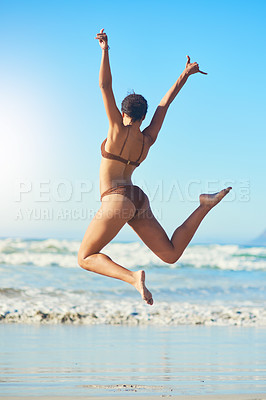 Buy stock photo Rearview shot of a young woman standing on the beach