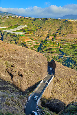 Buy stock photo Beautiful landscape of a countryside tar road with a cloudy blue sky and copy space. Roadway with cars driving to holiday destination close to agriculture farm in Spain on a summer afternoon or day