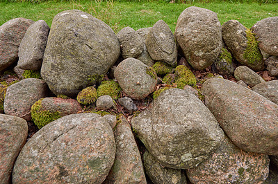 Buy stock photo Closeup of a stone wall made of boulders and rocks outside. Background of rustic, rural building and masonry material. Historic housing design or antique architecture of an urban structure outdoors