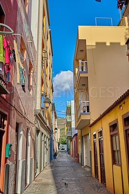 Buy stock photo Narrow street or alley between colorful buildings in Santa Cruz de La Palma. Bright and vibrant classical architecture in a small city or village. Beautiful houses or homes with a vintage design