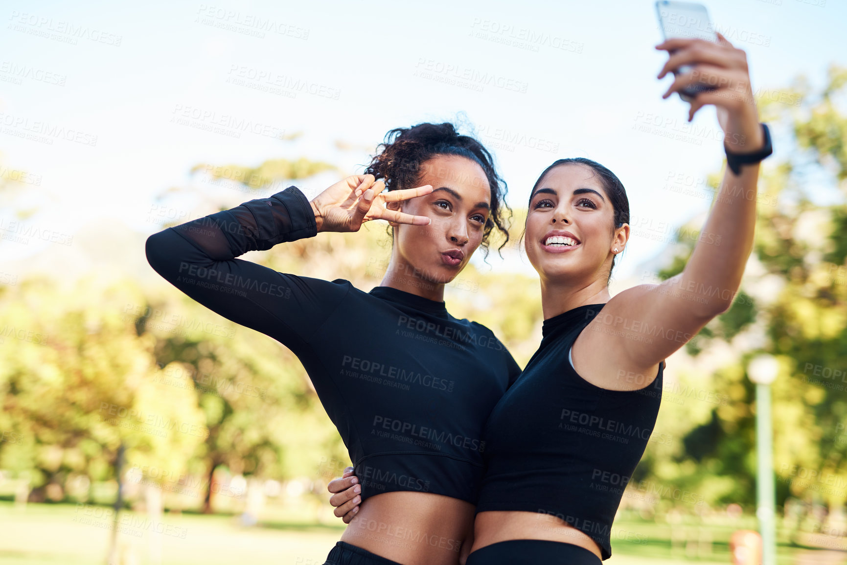 Buy stock photo Cropped portrait of two attractive young women posing for a selfie after their run together in the park