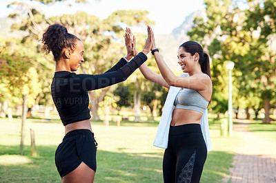 Buy stock photo Cropped shot of two attractive young women giving each other a high-five after their run in the park