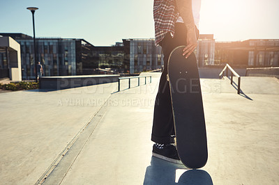 Buy stock photo Shot of an unrecognizable man holding his skateboard and getting ready to skate at a skatepark