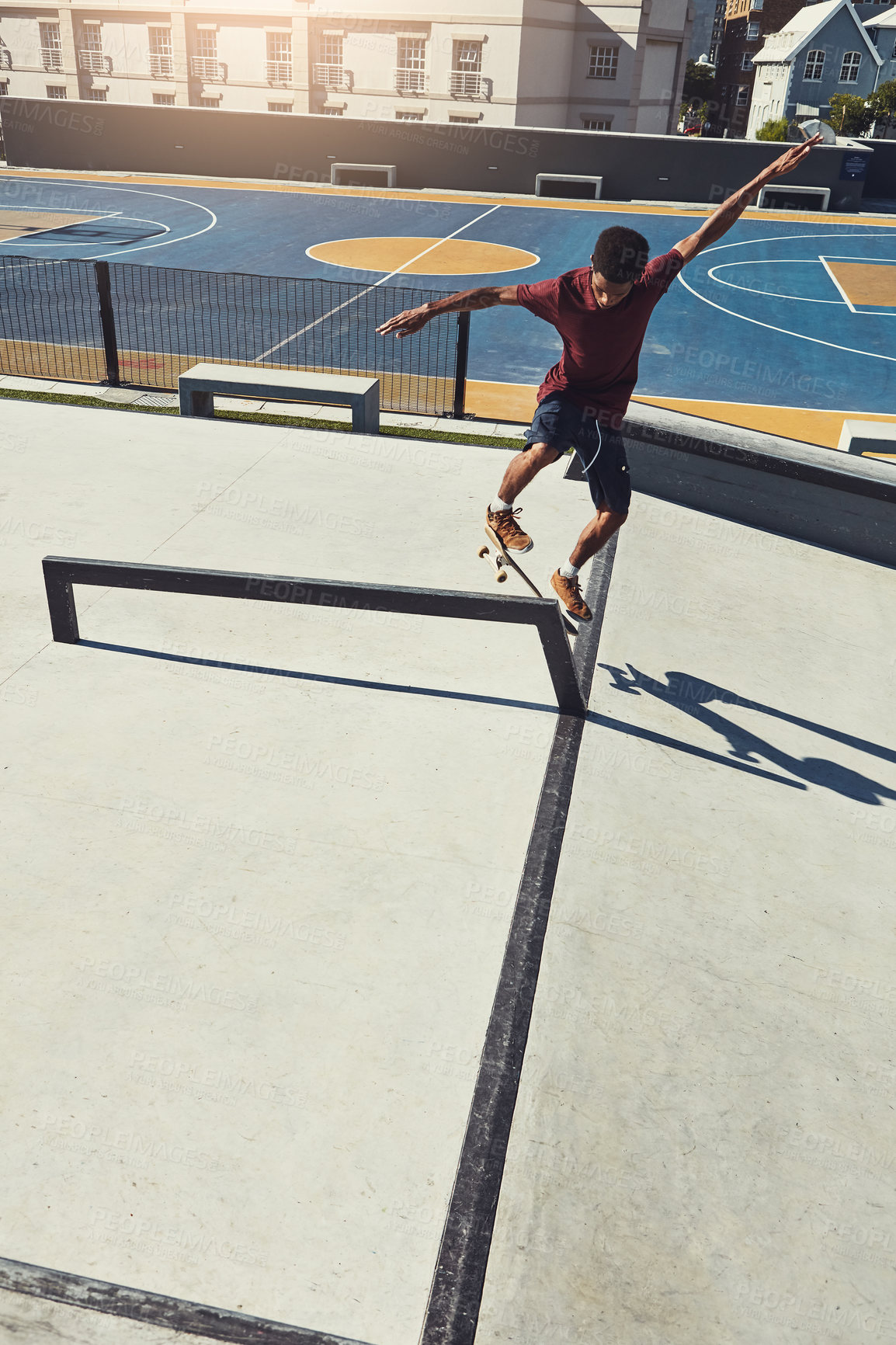 Buy stock photo Full length shot of a skateboarder doing tricks on a rail at a skate park