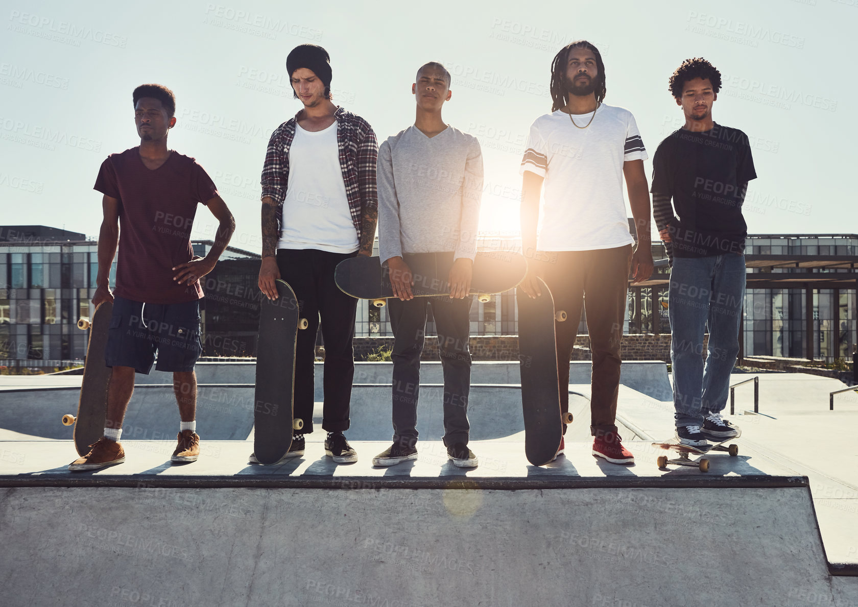 Buy stock photo Full length shot of a group of friends standing together on a ramp at a skatepark