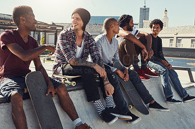 Buy stock photo Shot of a group of friends sitting together on a ramp at a skatepark
