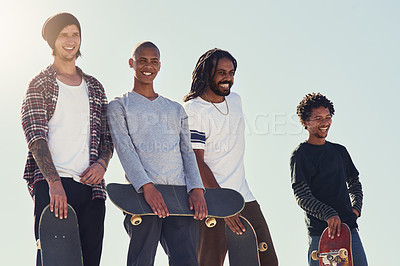 Buy stock photo Shot of a group of friends standing together on a ramp at a skatepark