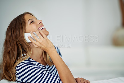 Buy stock photo Cropped shot of an attractive young woman laughing while talking on the phone at home