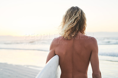 Buy stock photo Rearview shot of a young surfer looking at the ocean waves before going surfing at the beach