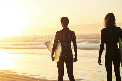 Buy stock photo Rearview shot of a young couple going surfing at the beach