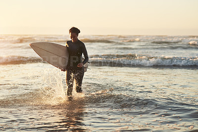 Buy stock photo Shot of a cheerful young woman going surfing at the beach