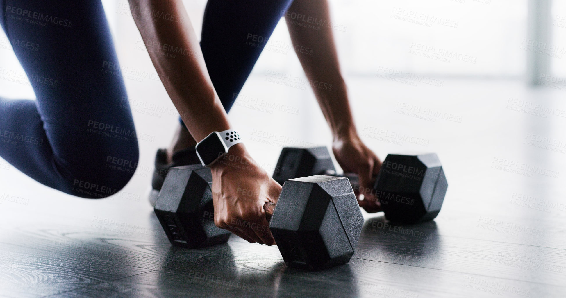 Buy stock photo Cropped shot of a woman working out with dumbbells in a gym