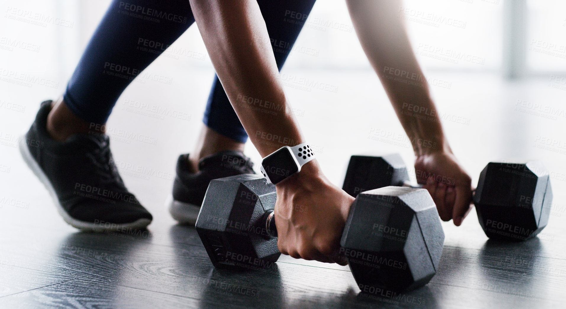Buy stock photo Cropped shot of a woman working out with dumbbells in a gym