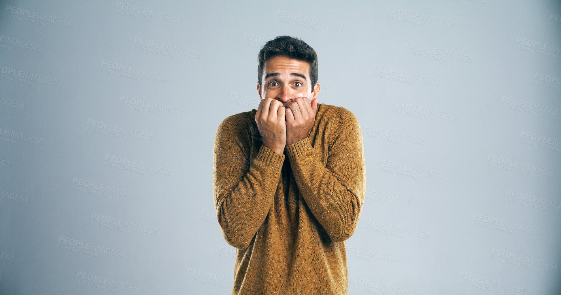 Buy stock photo Scared, man and nervous with fear in studio for horror, terror and panic for danger on mockup space. Worried person, nail biting and suspense with surprise, overwhelmed or bad news on gray background