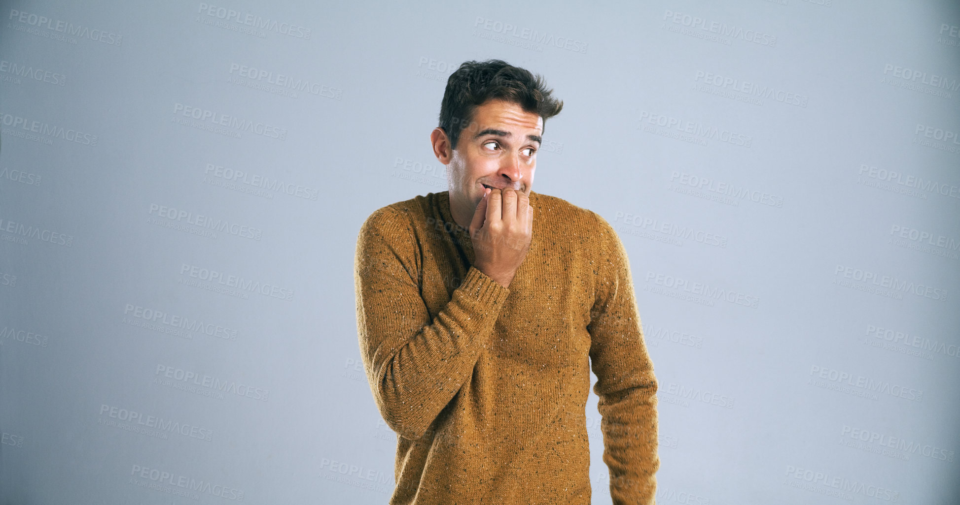 Buy stock photo Stress, man and biting nails with fear in studio for horror, terror and panic for danger on mockup space. Scared person, nervous and suspense with surprise, overwhelmed or bad news on gray background