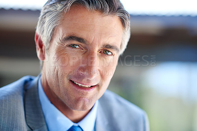 Buy stock photo Cropped portrait of a handsome mature businessman looking confident while working outdoors