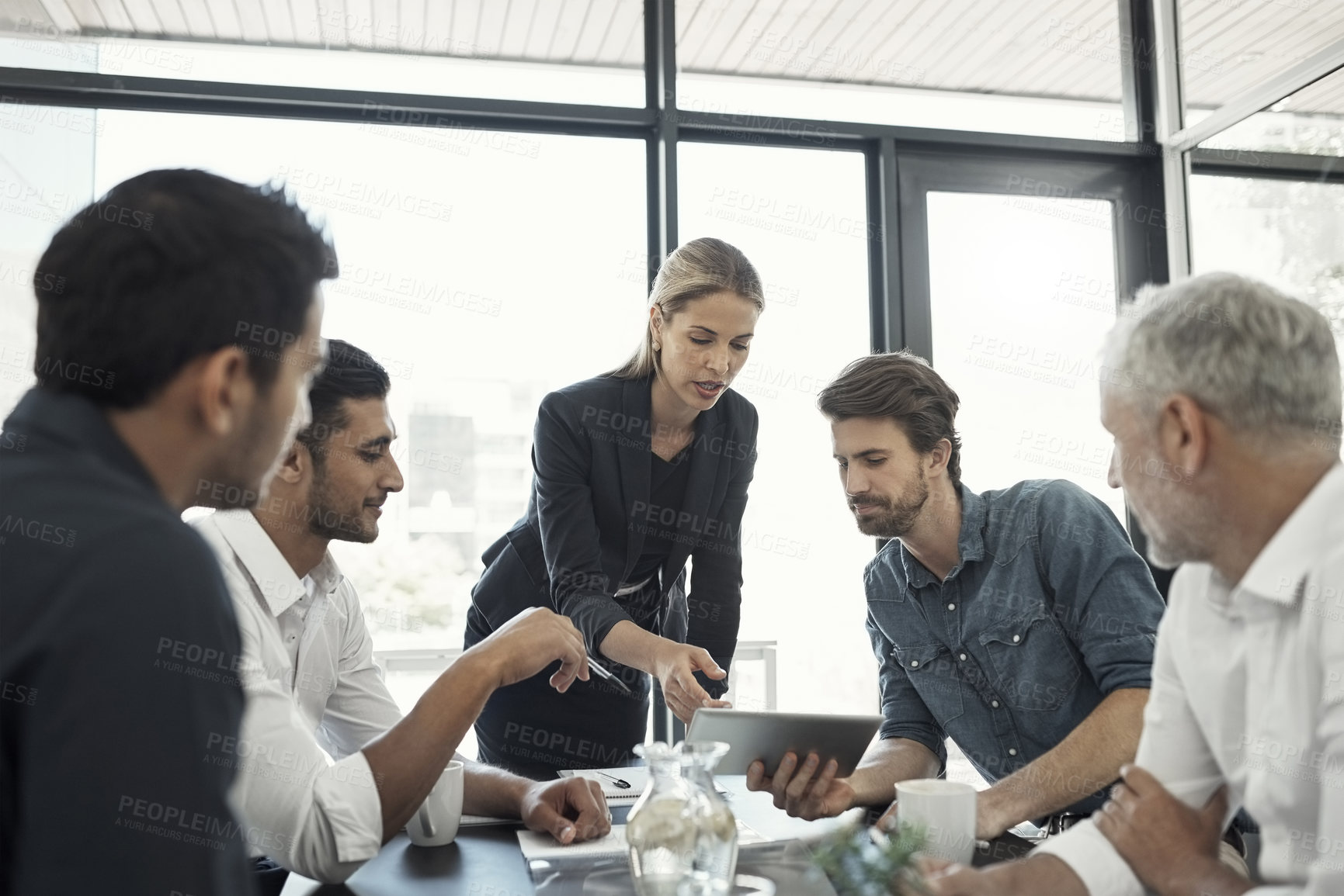 Buy stock photo Cropped shot of a businesswoman talking to colleagues sitting around a table in an boardroom