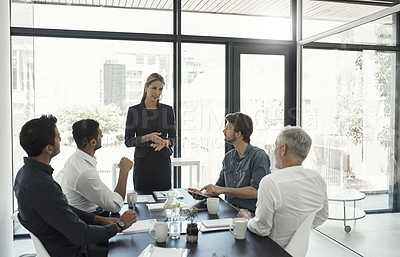Buy stock photo Cropped shot of a businesswoman talking to colleagues sitting around a table in an boardroom