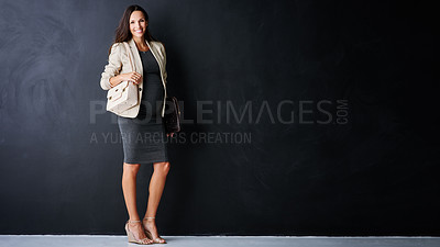Buy stock photo Studio portrait of a young pregnant businesswoman standing against a black background