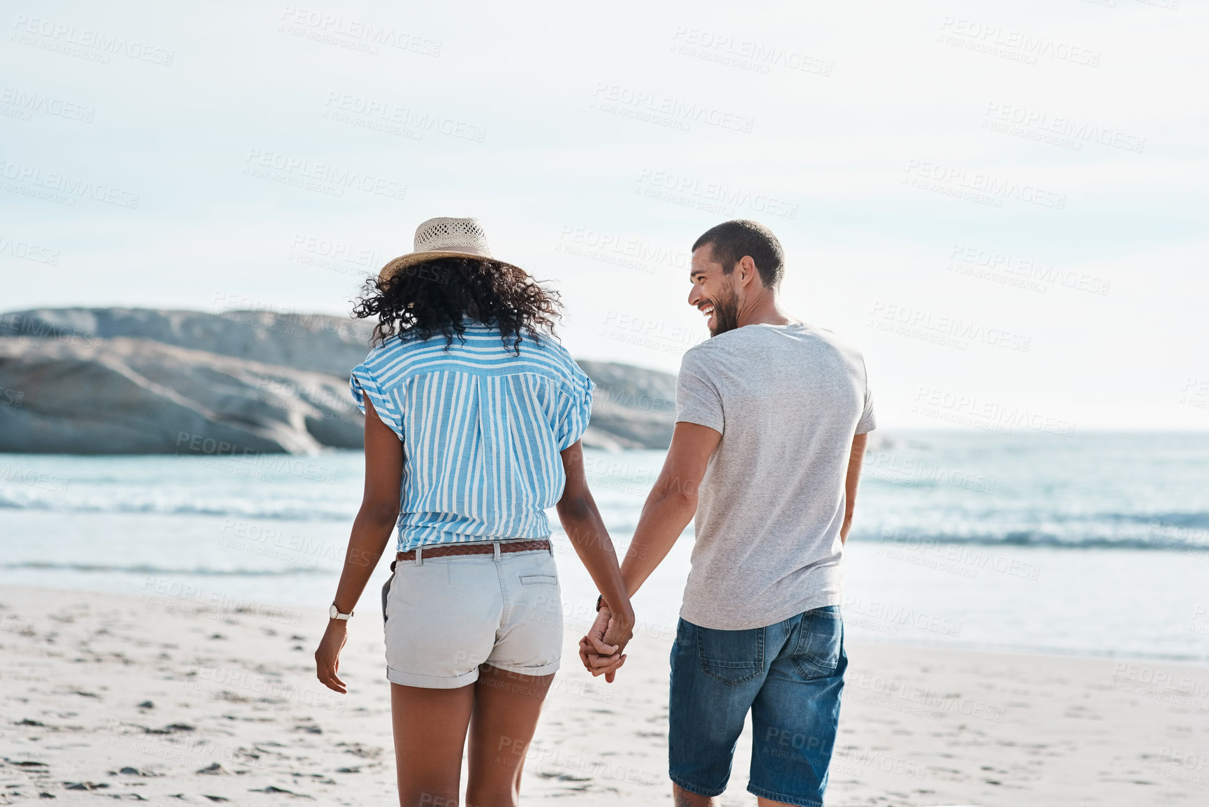 Buy stock photo Couple, back and holding hands at beach for summer, travel and tropical holiday together in San Diego. Man, woman and walking on sand by ocean for adventure, love and relax on vacation with partner