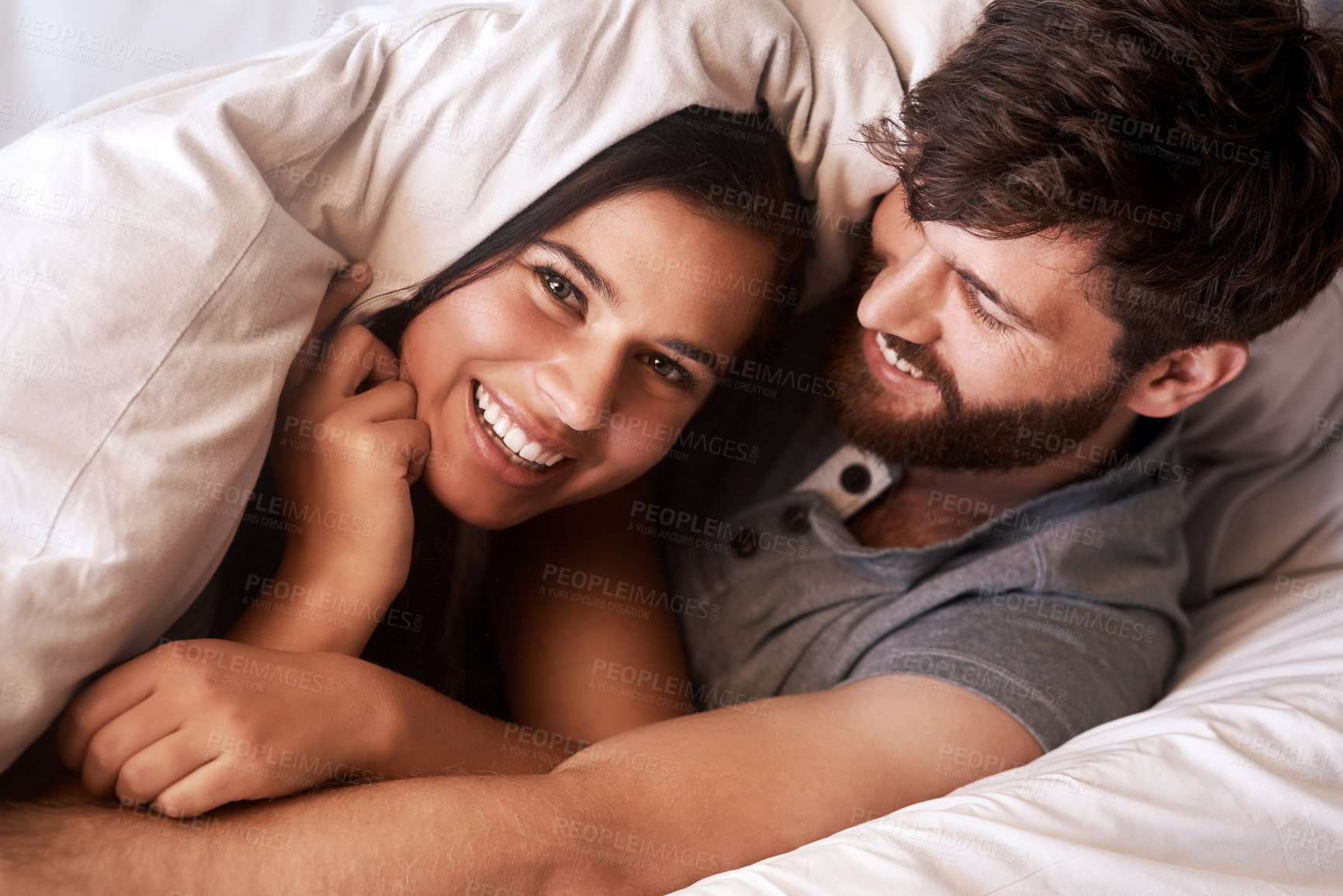 Buy stock photo Bed blanket, smile and portrait of happy couple, relax and enjoy morning together bonding on Ireland vacation holiday. Happiness, intimate and face of romantic woman, man or people in home bedroom