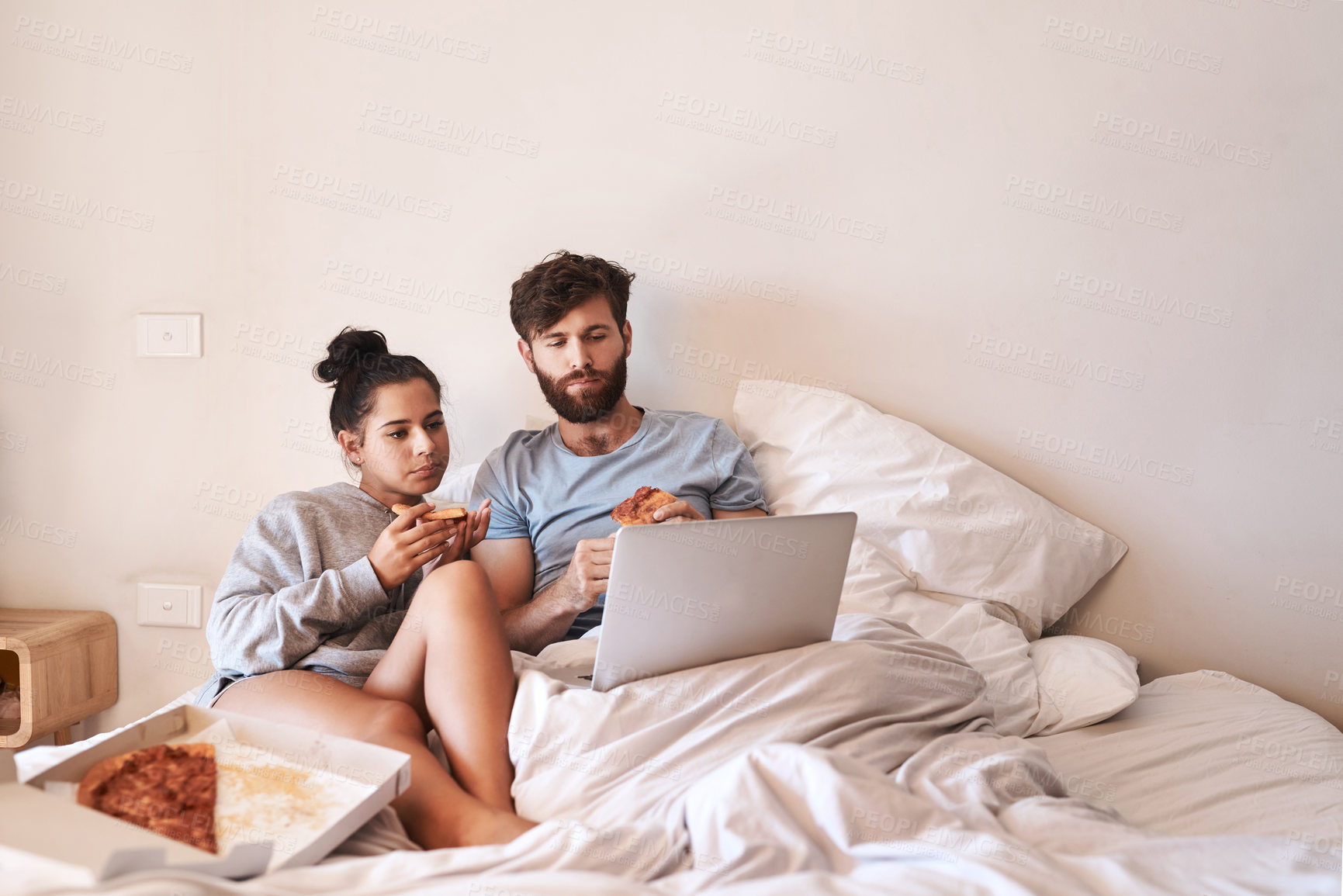 Buy stock photo Hungry couple, pizza and movie on laptop in bed with junk food and streaming series. Eating, computer video and meal in a bedroom at home with man and woman with bonding, online watching and mockup