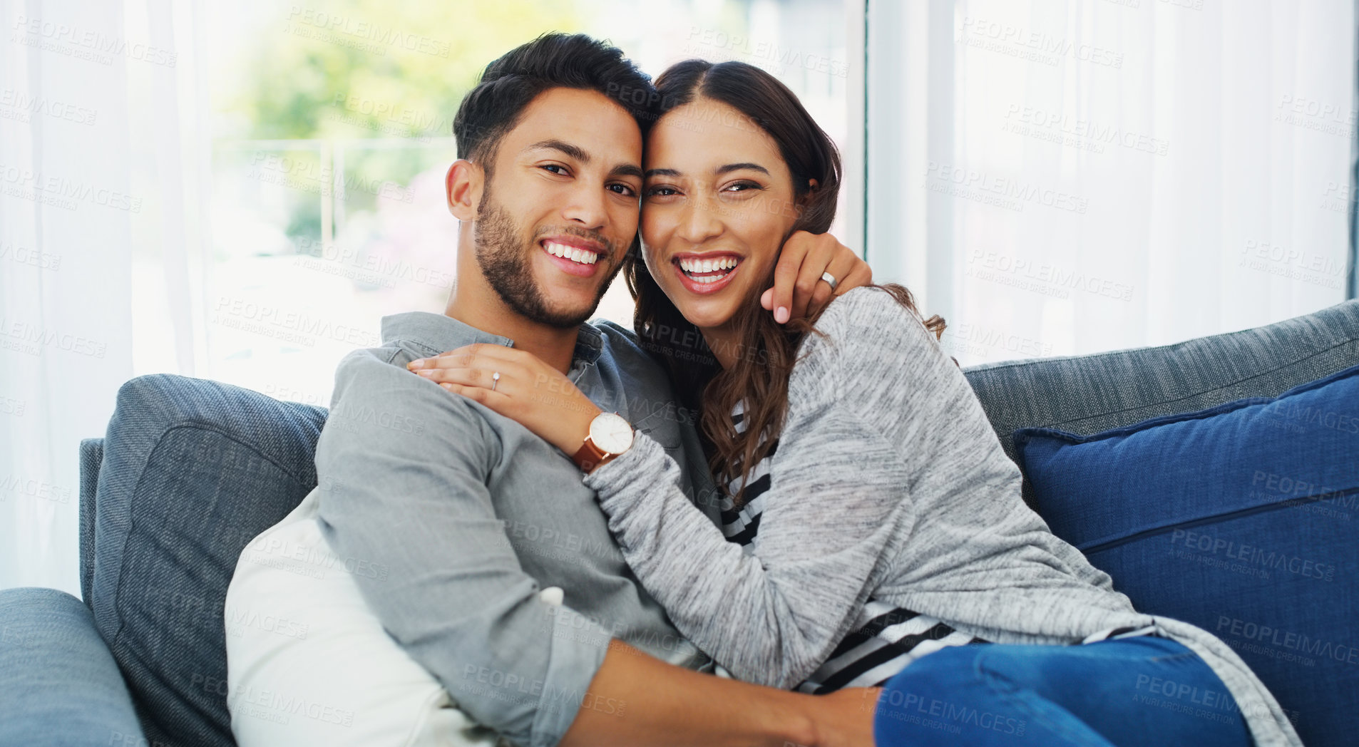 Buy stock photo Cropped portrait of an affectionate young couple holding each other while in their living room during the day