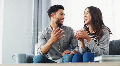 Buy stock photo Cropped shot of a happy young couple sitting on the sofa and talking in their living room during the day
